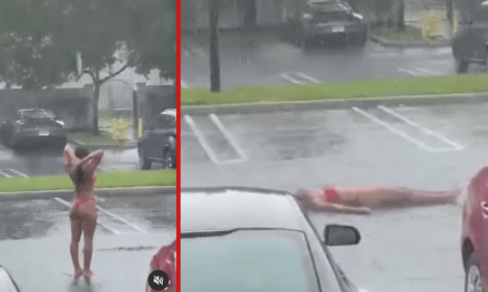 Joven en bikini sorprende refrescándose bajo la lluvia en estacionamiento de Miami